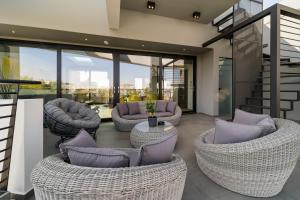 雅典The HostMaster Skyline Pool Oasis Penthouse的带沙发和椅子的客厅以及玻璃墙