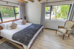 蒙塔古含羞草旅馆的一间卧室配有一张床、一把椅子和窗户。