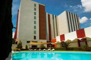 萨拉曼卡Bel Air Business Salamanca, Trademark by Wyndham的大楼前设有游泳池的酒店