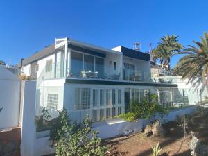 圣巴托洛梅Apartamento Oasis Palmeras 4的棕榈树海滩上的白色房子