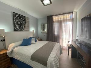圣巴托洛梅Apartamento Oasis Palmeras 4的一间卧室配有一张床、一张书桌和一个窗户。