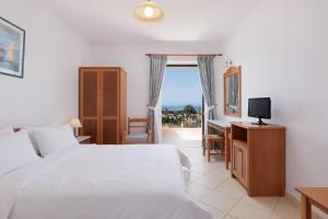 阿查拉维开元度假酒店的一间卧室配有一张床、一张书桌和一台电视