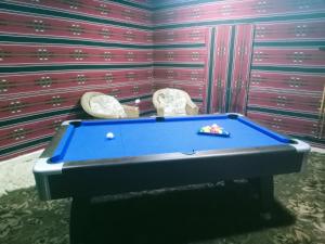 瓦迪穆萨Infinity Lodge的一张台球桌,房间配有两把椅子