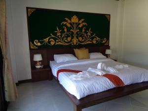 Ban Khao ThongPARADIS VERT的绿墙客房内的两张单人床