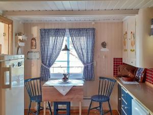 芬斯内斯Holiday home Finnsnes的厨房配有桌子和两把椅子,设有窗户。
