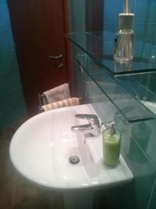 奥里奥阿塞里奥BGY Airport Guesthouse的浴室水槽上放着绿色的蜡烛