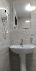 布拉索夫Casa Familiei的浴室设有白色水槽和镜子