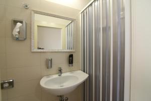 里米尼Hotel Soave的浴室配有盥洗盆和带镜子的淋浴