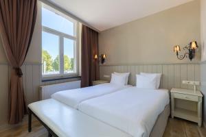 马斯特里赫特Amrâth Hotel Bigarré的卧室设有一张白色大床和一扇窗户。