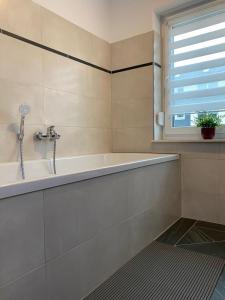 奥舍尔斯莱本Gästewohnung 4的白色的浴室设有浴缸和窗户。