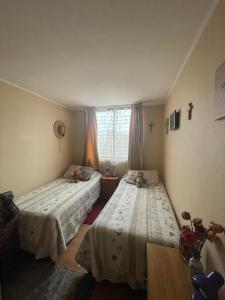 圣地亚哥Departamento en Condominio Cerrado La Florida的一间卧室设有两张床和窗户。
