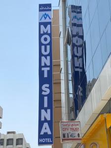 迪拜MOUNT SINA HOTEL By AURA的建筑一侧的酒店标志