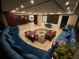 迪拜MOUNT SINA HOTEL By AURA的享有带蓝色沙发和桌子的客厅的顶部景色。