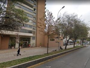 圣地亚哥Departamento en Condominio Cerrado La Florida的一个人在建筑物前的人行道上走
