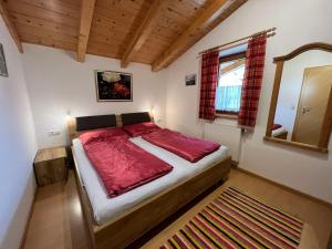 AngerbergApartment Schusterhäusl Lackner by Interhome的一间卧室配有一张带红色床单和镜子的床