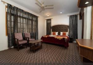 斯利那加Hotel Al Azrah的配有一张床和一张书桌的酒店客房