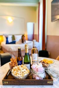 尼斯Aparthotel AMMI Vieux Nice的一张桌子上装有两瓶葡萄酒和小吃的托盘