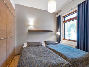 于莱Holiday Home Ylläs chalets 2405 by Interhome的一间卧室配有一张带蓝色棉被的床和窗户。