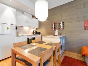 于莱Holiday Home Ski chalet vii 7406 by Interhome的一间带木桌的厨房和一间餐厅