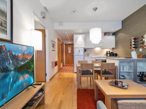 于莱Holiday Home Ski chalet vii 7406 by Interhome的一间带大电视和厨房的客厅