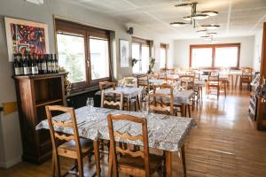 布勒伊-切尔维尼亚HOTEL SPORTING的用餐室配有桌椅和葡萄酒瓶