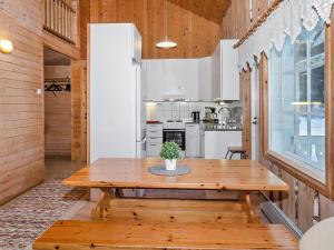 AhmovaaraHoliday Home Kultaranta by Interhome的一间带木桌的用餐室和一间厨房