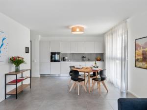 洛迦诺Apartment LocTowers A4-4-3 by Interhome的厨房以及带桌椅的用餐室。