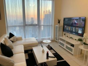 迪拜Torch 77的客厅配有白色沙发和平面电视。