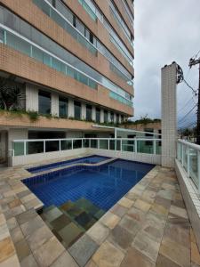 大普拉亚Apto com Piscina e Churrasqueira的大楼前的游泳池
