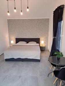 GiarmataKevin&Jessica Rooms的一间卧室配有一张大床和两张桌子