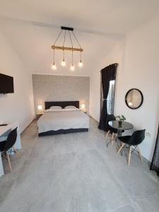 GiarmataKevin&Jessica Rooms的卧室配有一张床和一张桌子及椅子