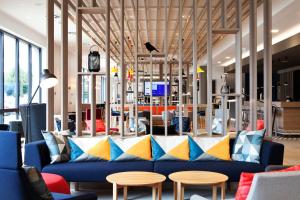 巴塞尔Holiday Inn Express & Suites - Basel - Allschwil, an IHG Hotel的大堂设有蓝色的沙发和桌子