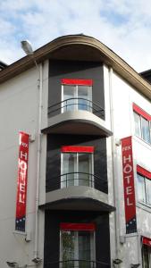 洛里昂Logis REX HOTEL Lorient的黑色和白色的建筑,设有红色的窗户