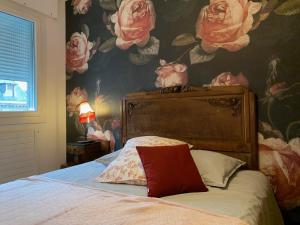 罗德兹Chez Paul et Louis的一间卧室配有一张带花卉壁纸的床