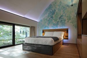 米兰VERSOVERDE HOTEL Alzaia Naviglio Grande的卧室配有一张大床,墙上挂有绘画作品