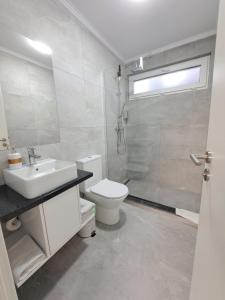 GiarmataKevin&Jessica Rooms的浴室配有卫生间、盥洗盆和淋浴。