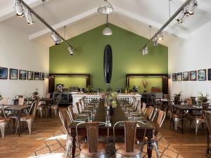 格拉本斯塔特Matador Lodges的配有桌椅和绿色墙壁的客房