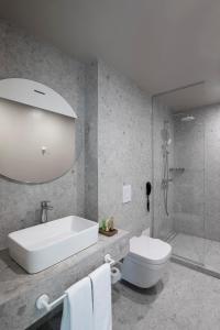 金沙Umani Hotel - Free Beach - Free Parking的带浴缸、卫生间和淋浴的浴室。