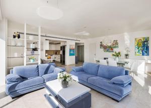 荷兹利亚BMarina view 2bd Luxury Ap的一间带蓝色沙发的客厅和一间用餐室