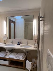 圣凯撒利亚温泉Le Capase Resort Salento的一间带两个盥洗盆和大镜子的浴室