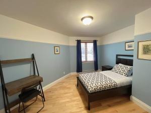 魁北克市Sweetwater House的一间卧室配有一张床和一架钢琴