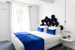 巴黎34B酒店 - 阿斯托利亚酒店的一间卧室配有一张带蓝色枕头的大床