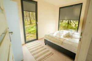 尤斯托尼莫斯基Ustronie Park - beach resort的一间卧室设有一张床和一个大窗户