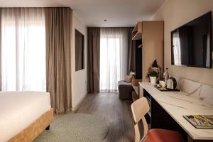 埃尔哥茨拉Strand Suites by NEU Collective的配有床和书桌的酒店客房