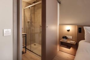 埃尔哥茨拉Strand Suites by NEU Collective的带淋浴的浴室和1间带1张床的卧室