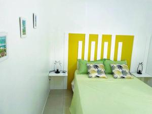 勒拉芒坦Bel appartement dans écrin de verdure的一间卧室配有带两个枕头的绿色床