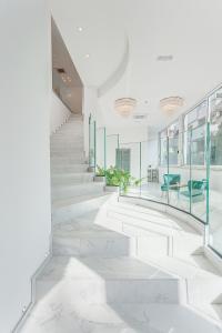 里米尼Hotel Anversa Rimini的走廊上设有白色大理石楼梯和玻璃墙