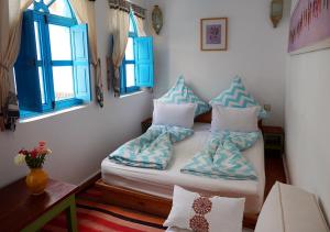 马拉喀什达尔达乌德旅馆的客房配有带枕头的床和窗户。