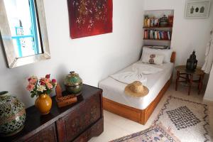 马拉喀什达尔达乌德旅馆的一间卧室配有一张床和一张鲜花桌