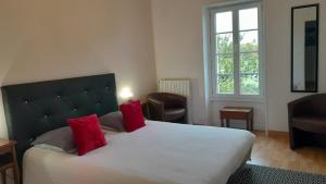 圣哲伦Domaine de Pelouaille - chambre d'hôtes的卧室配有带红色枕头的大型白色床